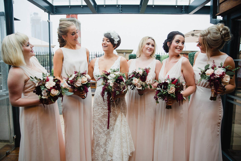 Copy of bridesmaids all holding bouquets while looking at camera for great john street hotel group photograph