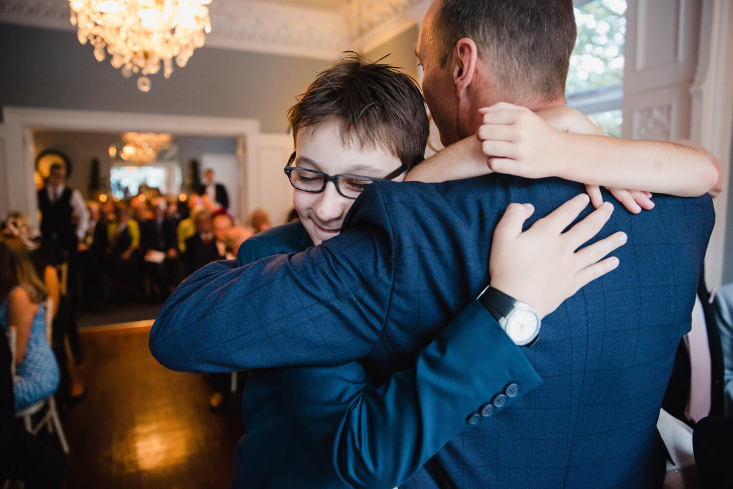 best man shares intimate hug with groom after wedding ceremony