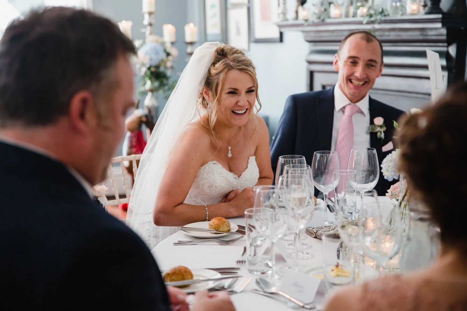 bride and groom laughing at jokes on table