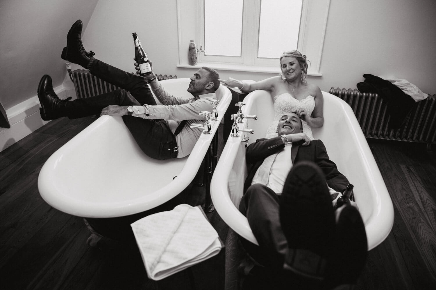 black and white photograph of bride and groom in bathtubs at didsbury house hotel