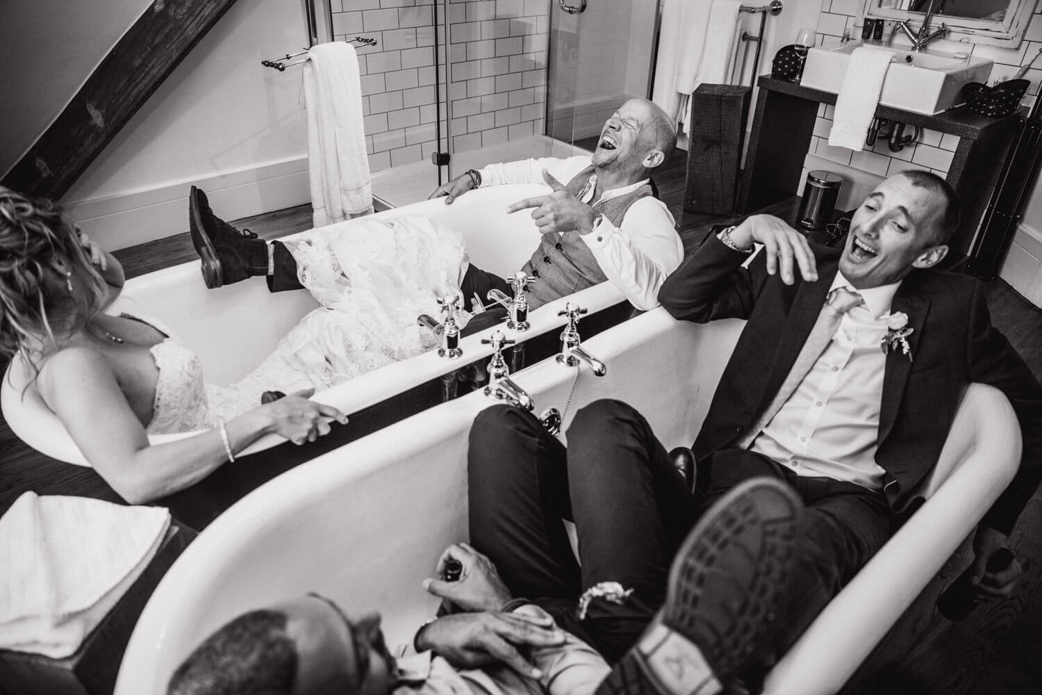 black and white photograph of wedding guests in bathtubs at didsbury house hotel