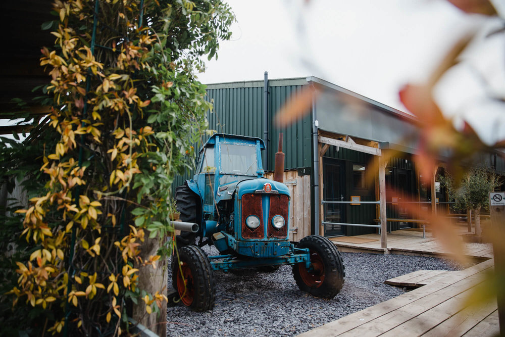 Rustic barn tractor parked outside entrance to wedding venue