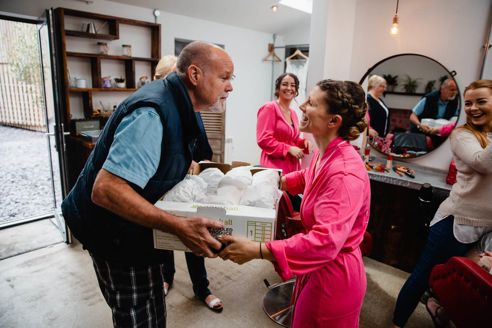 father of bridesmaid delivers sandwiches to bridal party before ceremony 