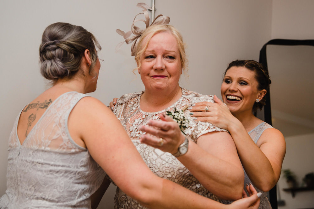 intimate moment as the mother of bride being comforted by bridesmaids