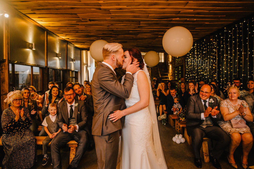 wedding service first kiss of newlyweds as bridal party celebrate