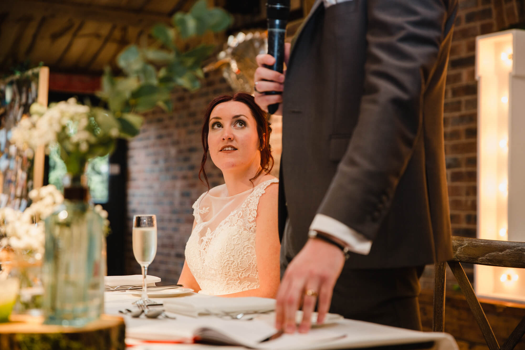 bride looking up at groom during speeches at Owen House Wedding Barn