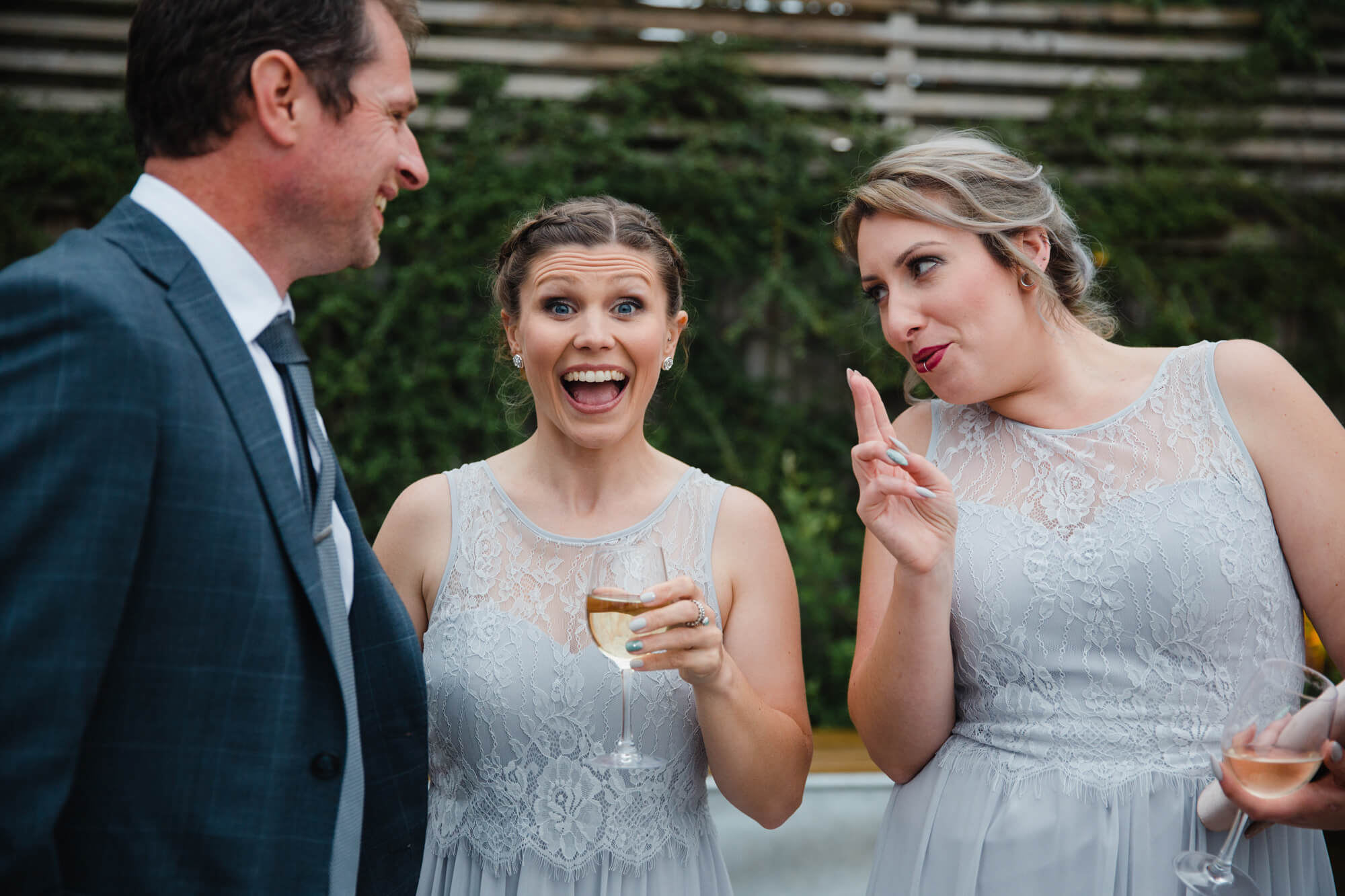 bridesmaids in wedding gowns having fun outside in barn gardens
