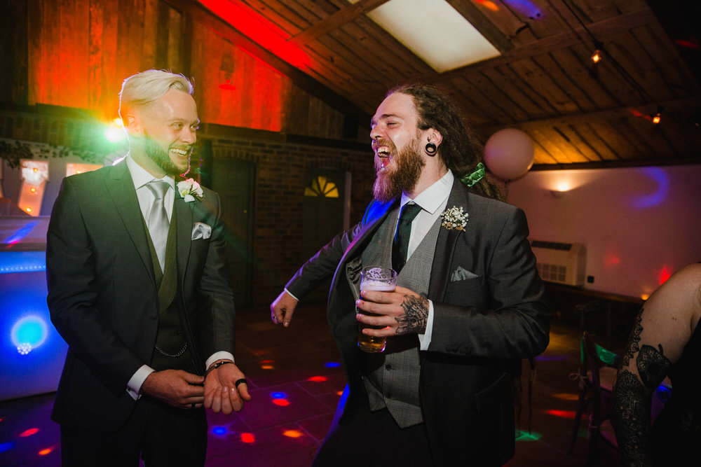 best man enjoying drinks with groom on dance floor