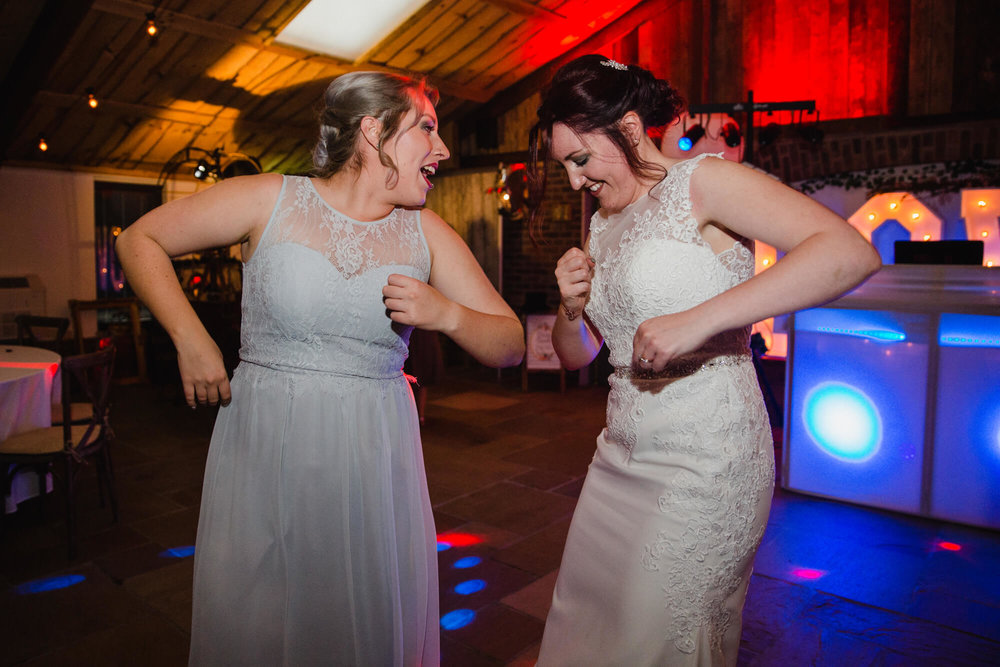 bride and bridesmaid dancing together on dance floor