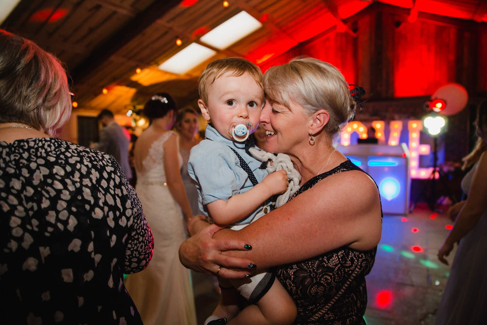page boy being held on dance floor for intimate photograph looking into camera