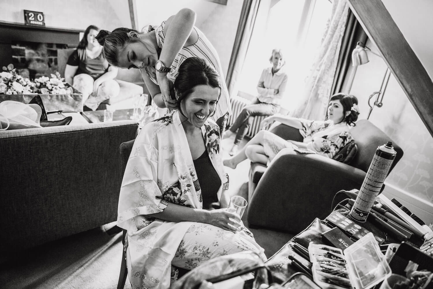 black and white photograph of bride having hair styled