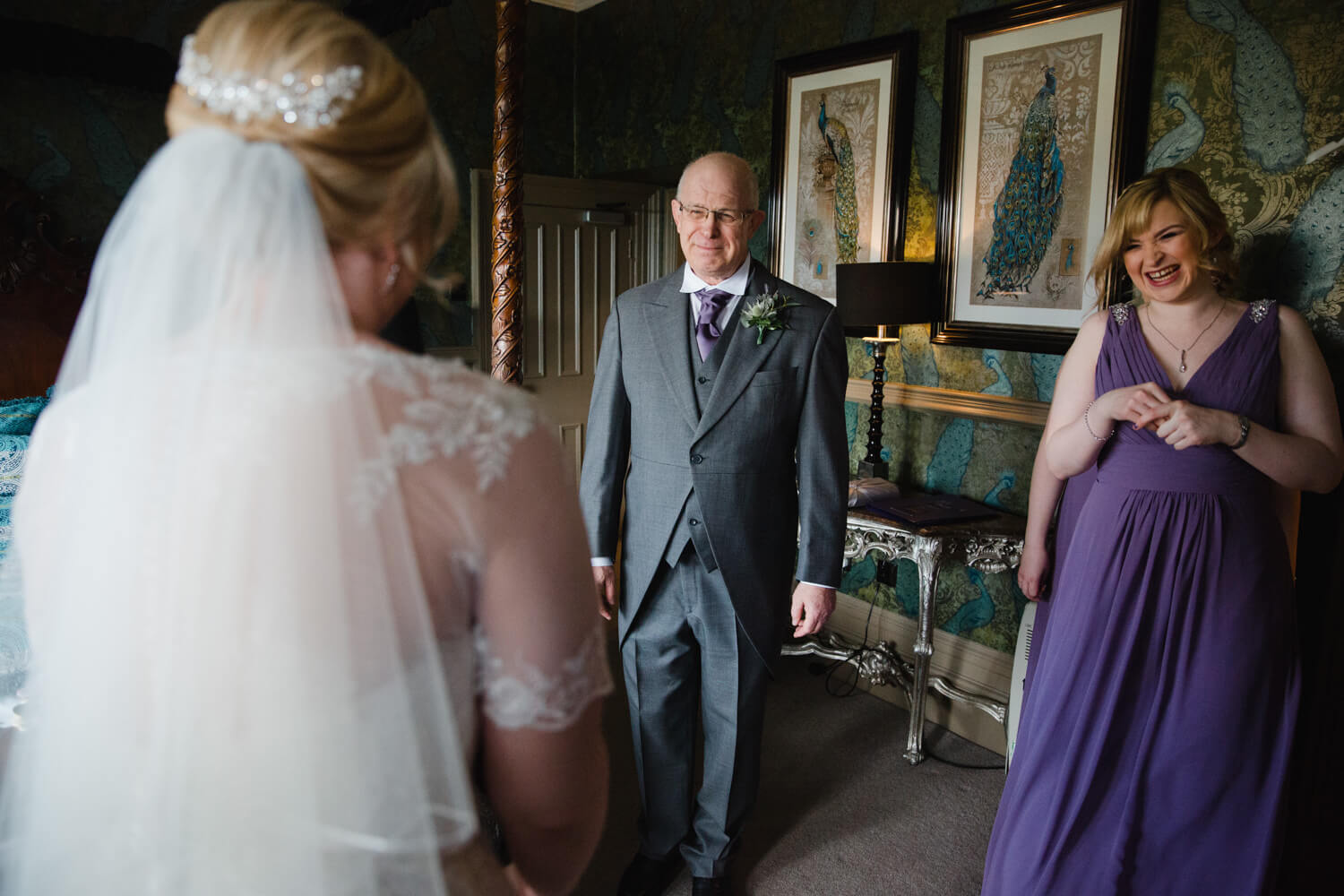 father of bride greets daughter in bridal suite for intimate moment before wedding nuptials