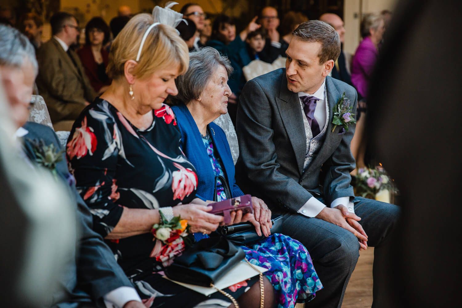 Groom with mother sat on top of aisle at Mitton Hall