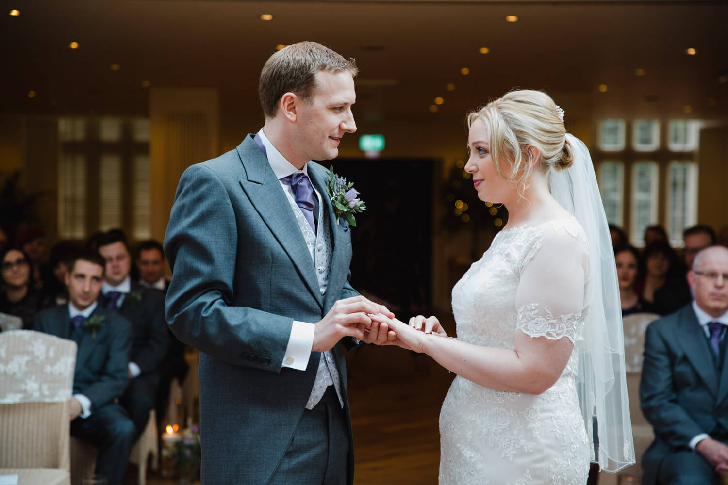 wedded couple exchanging wedding rings during service at Mitton Hall