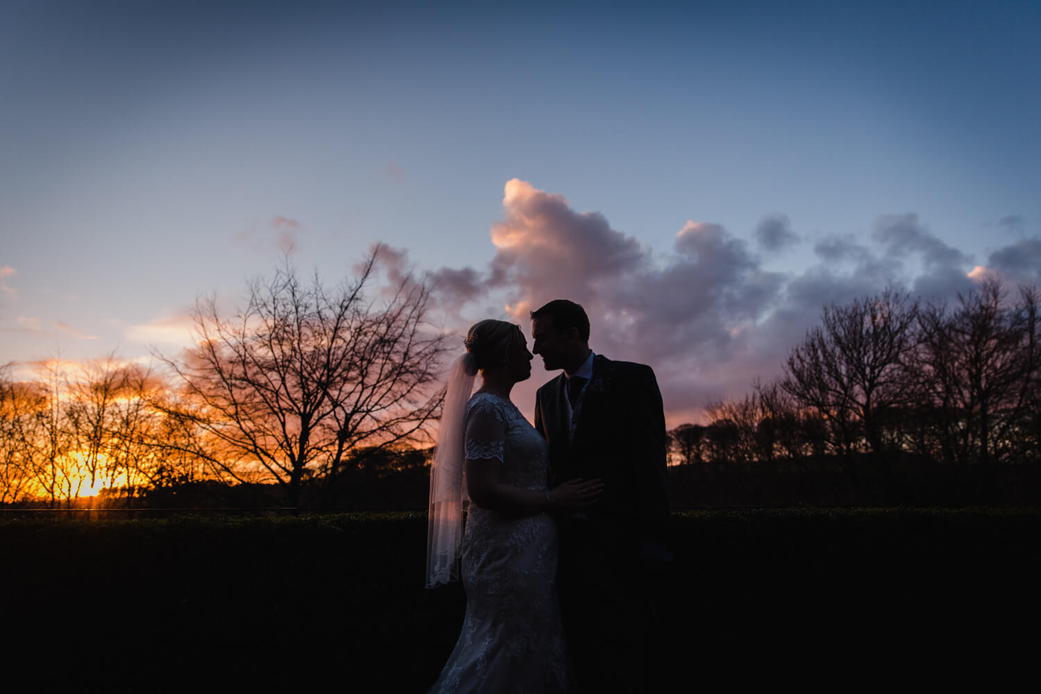 low light exposure silhouette of newlyweds with sunset background