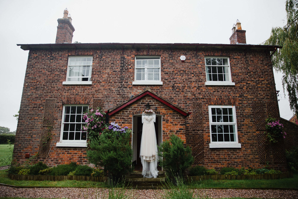 Wedding Dress hung in doorway to stock farm