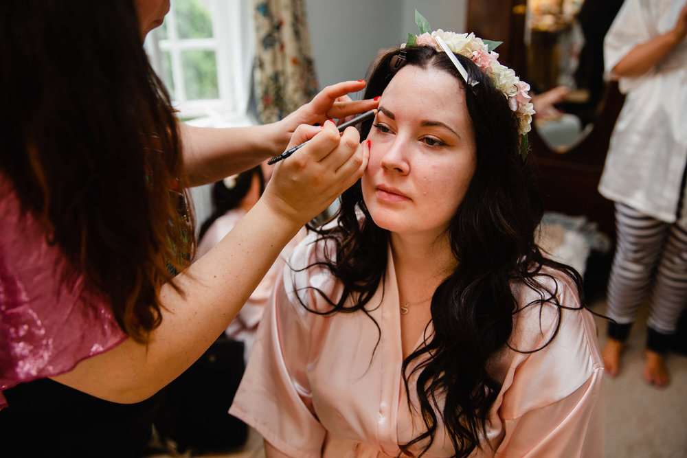bridesmaid having make up applied before ceremony at Stock Farm
