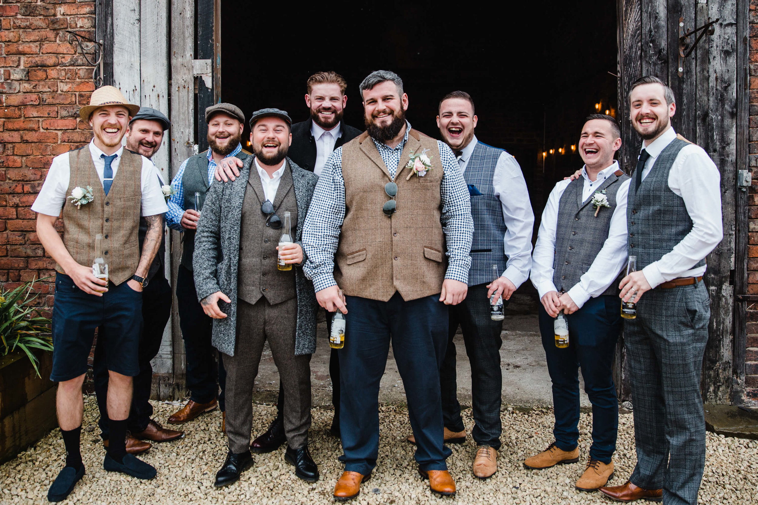 groom and groomsmen smiling at camera before wedding service