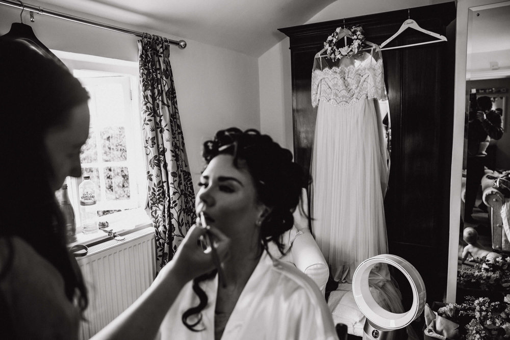 black and white monochrome photograph of wedding dress hung on cupboard