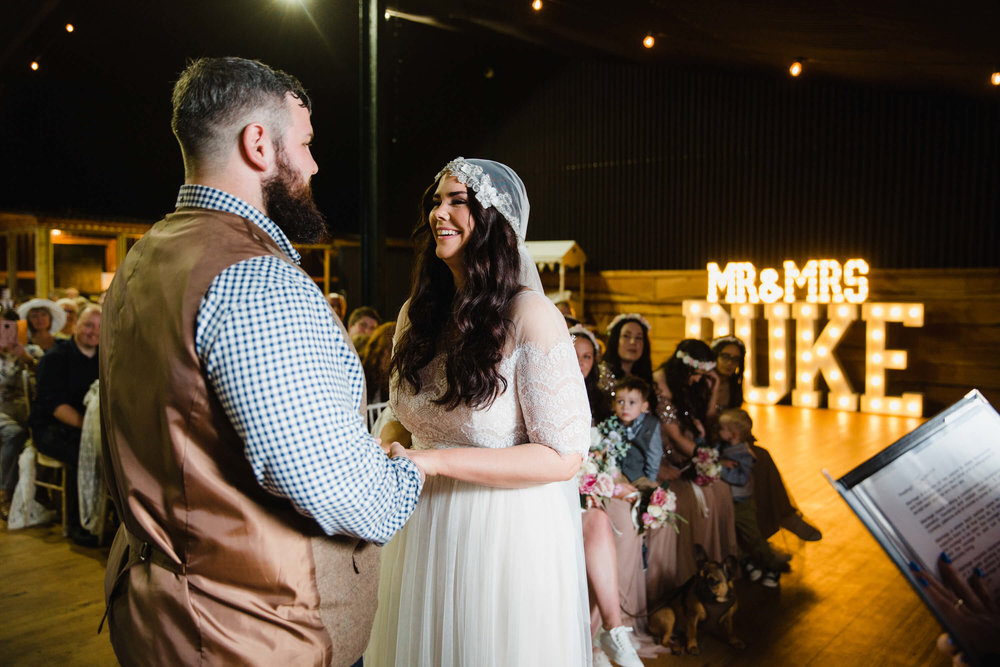 Newly wedded couple at top of aisle for nuptials with store light up letters in backdrop