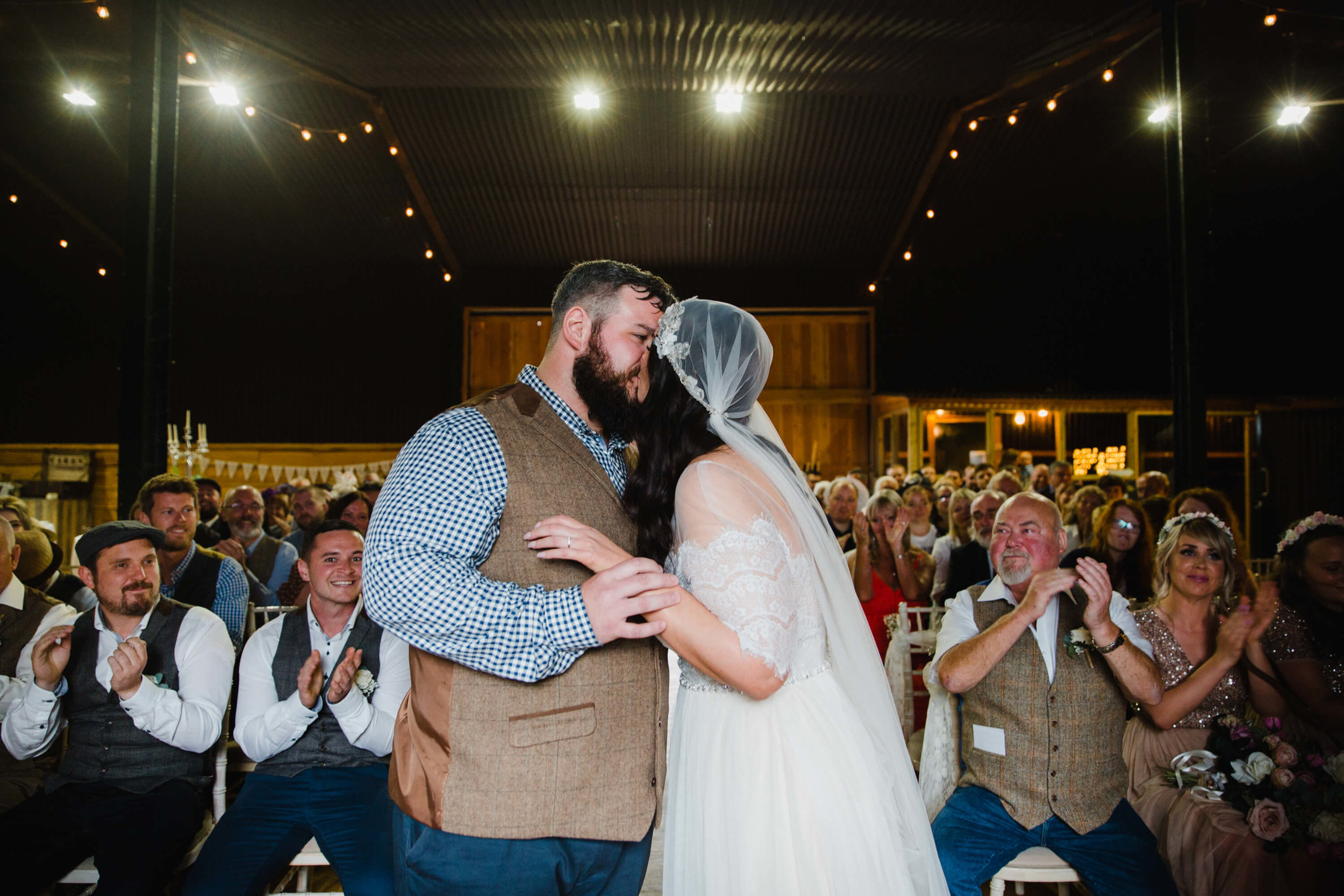 First kiss as newlyweds kiss in front of family and friends