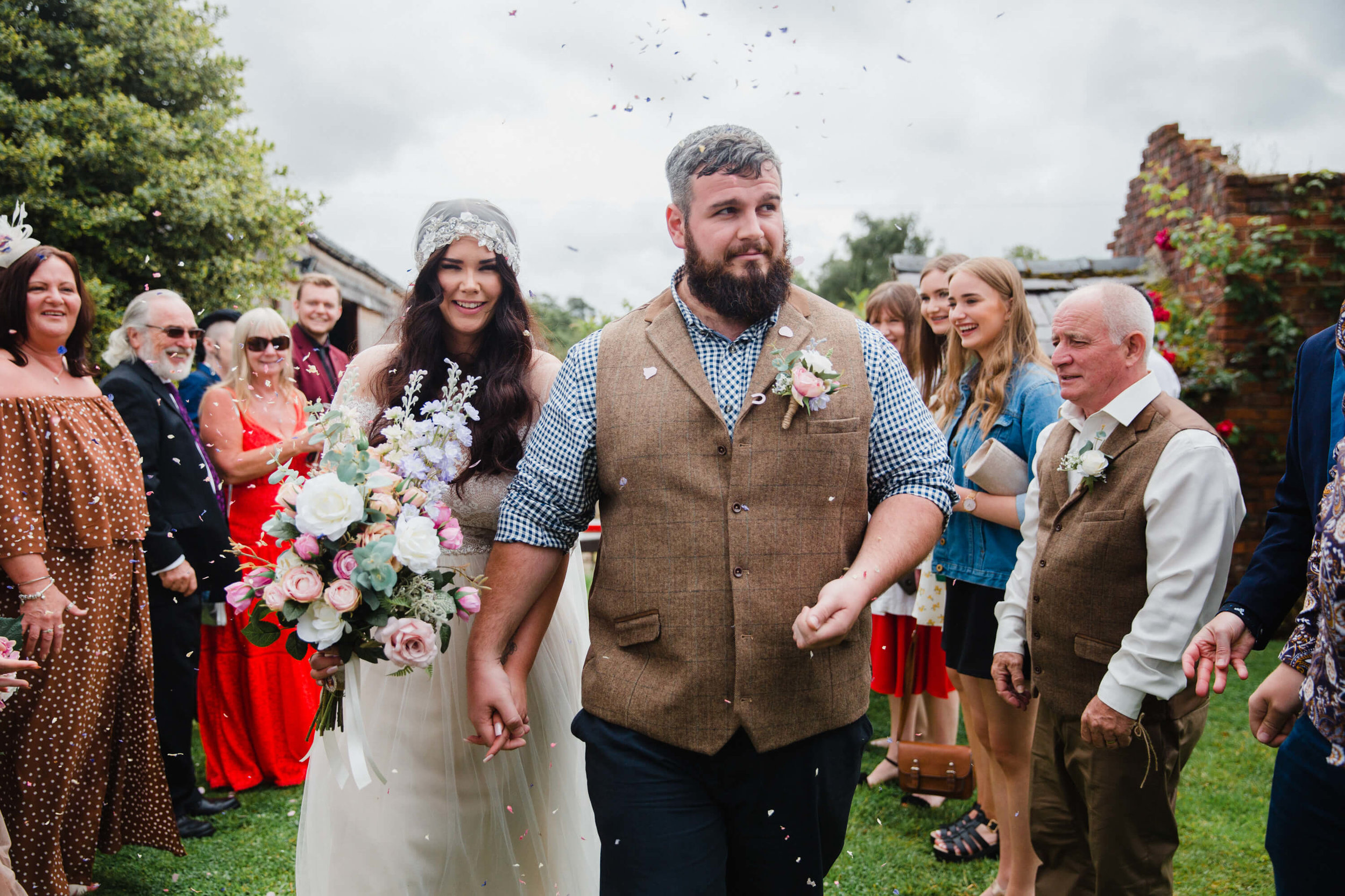 bride and groom step out into pastures for confetti throwing