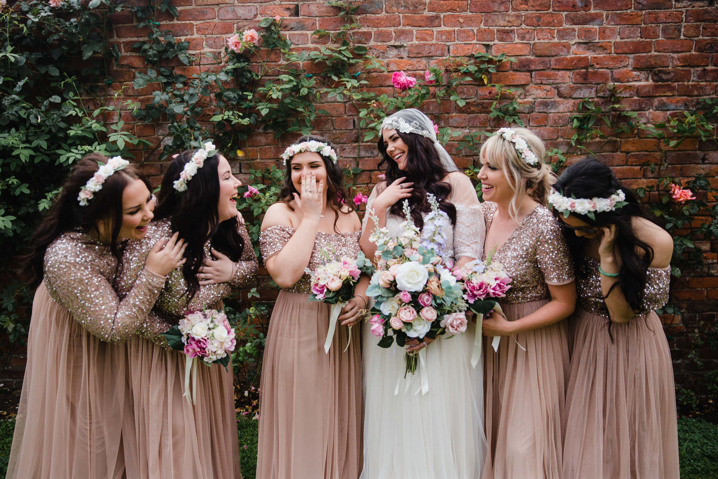 bride sharing a natural moment with bridesmaids while all holding bouquets