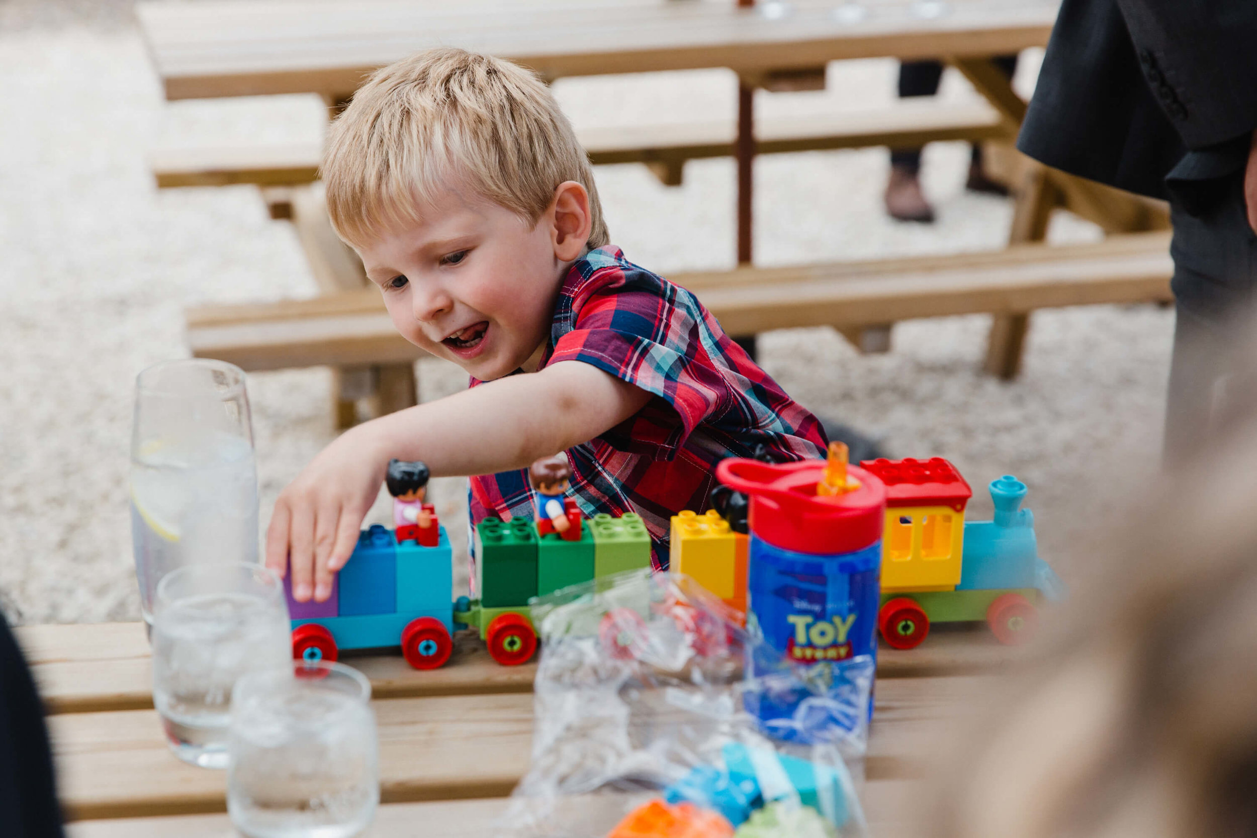 page boy pushing toy train on wooden table