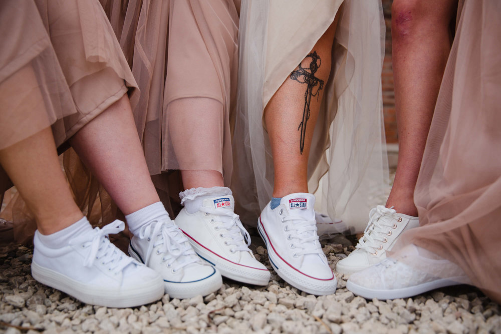 close up photograph of bridesmaids footwear white converse trainers