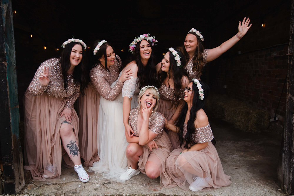 bridesmaids pose together for camera at entrance to farm homestead 