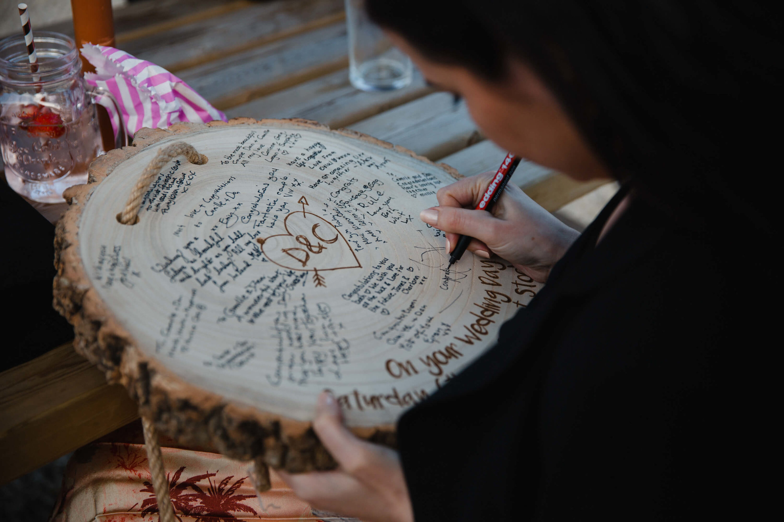 wedding guest writing on to wooden tree ring