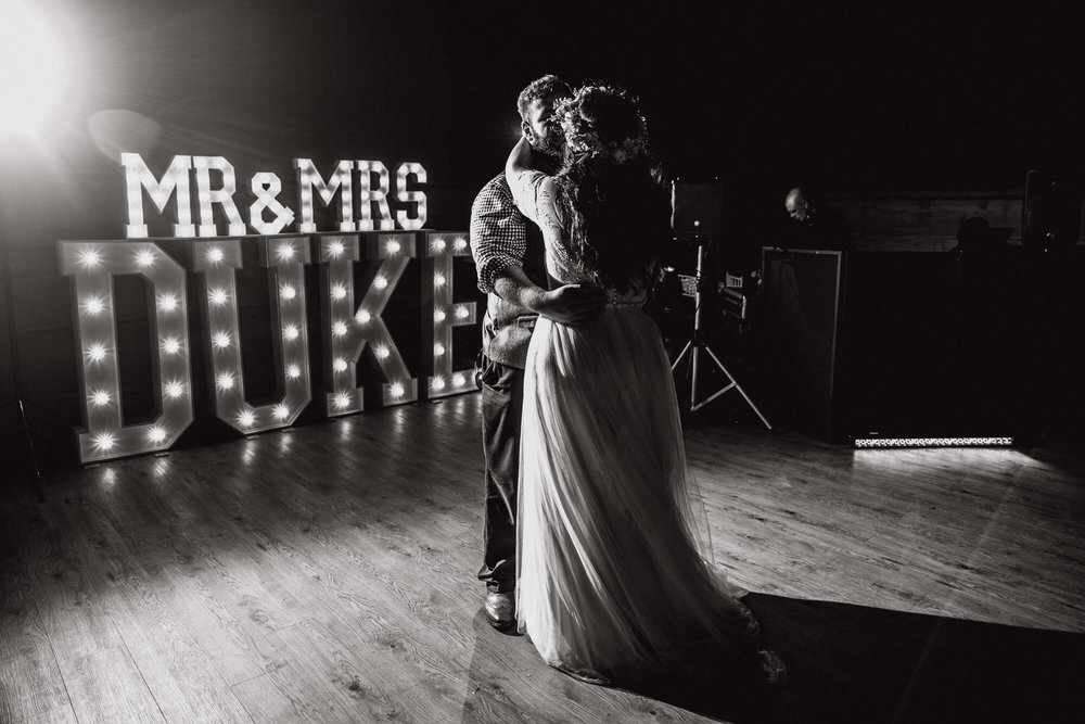 monochrome photograph of first dance and light up lettering