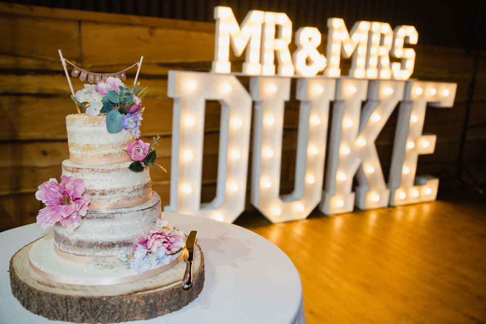 wedding cake with light up lettering in backdrop