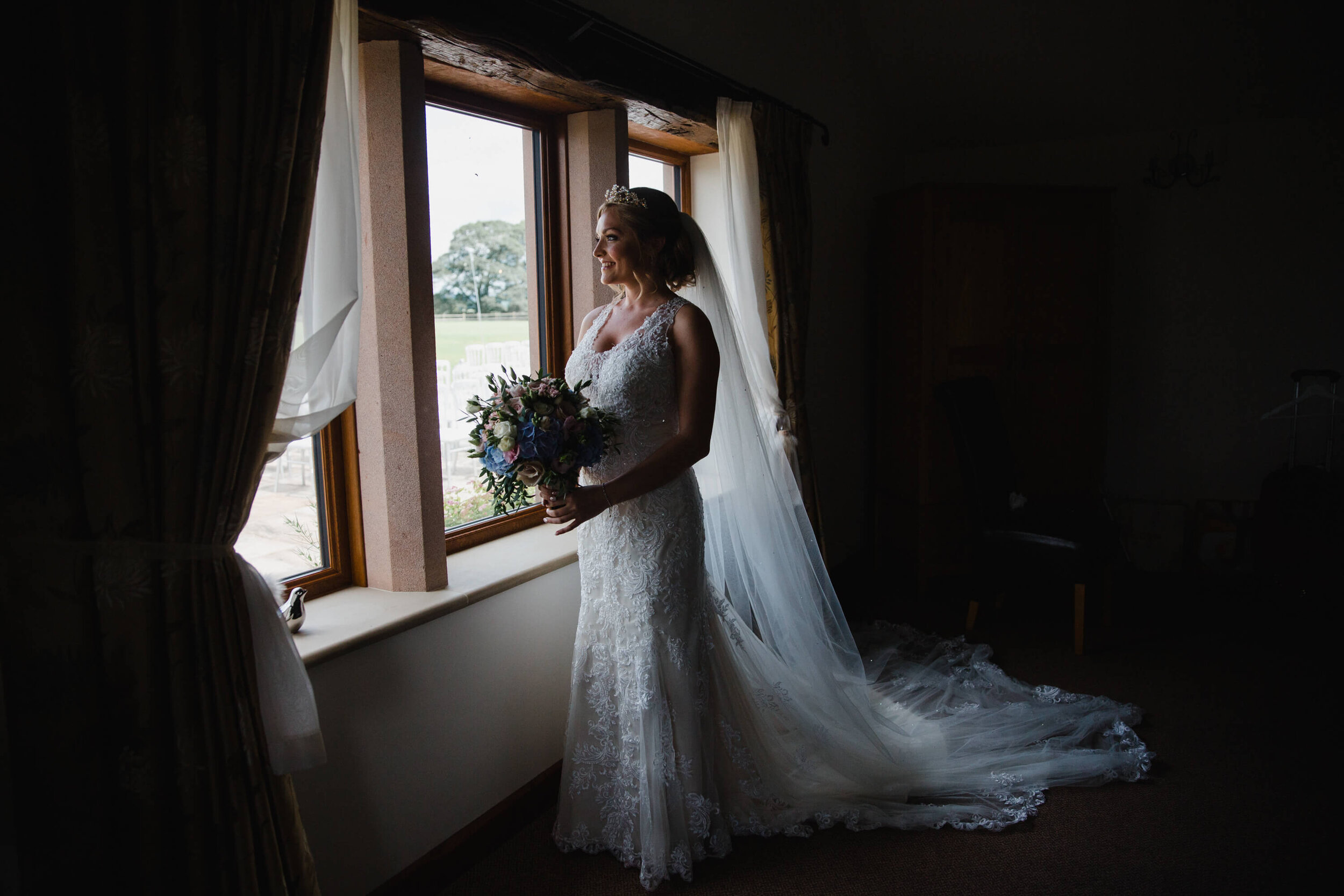 low light exposure portrait of bride looking out from building window