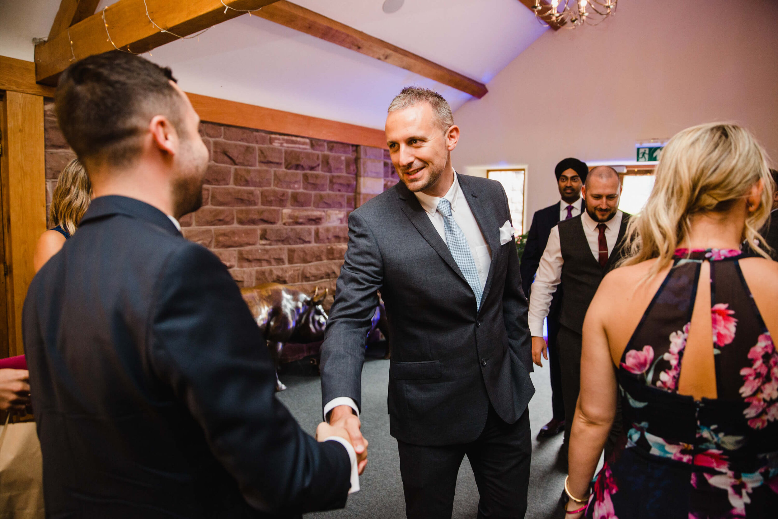 wedding guest greeting groom in entrance to estate