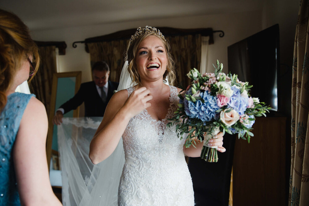 bride shares laugh as father arranges veil