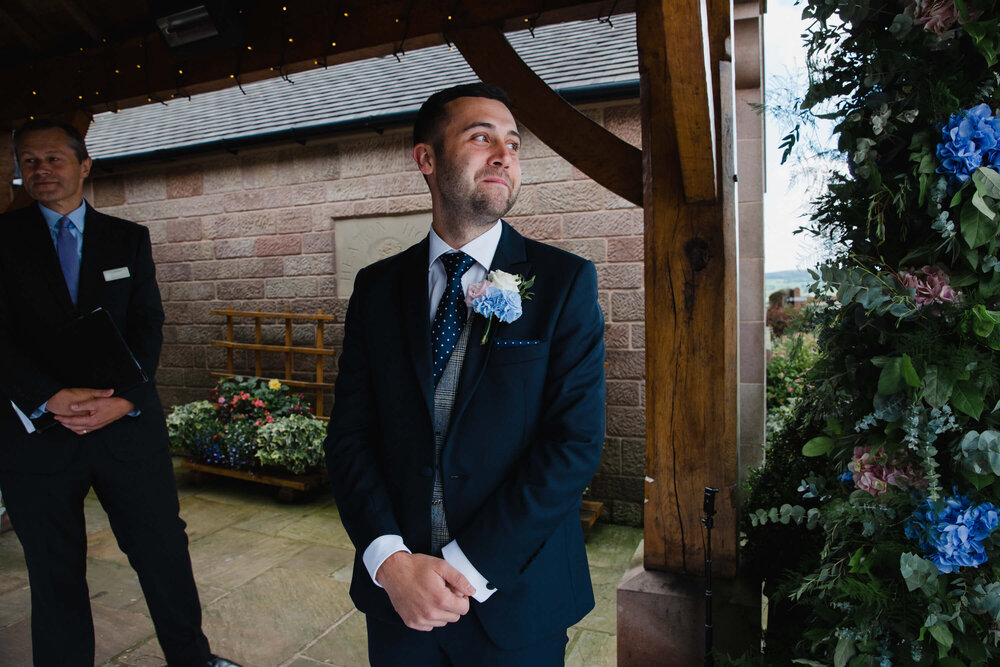 groom at top of aisle awaiting bride during ceremony processional