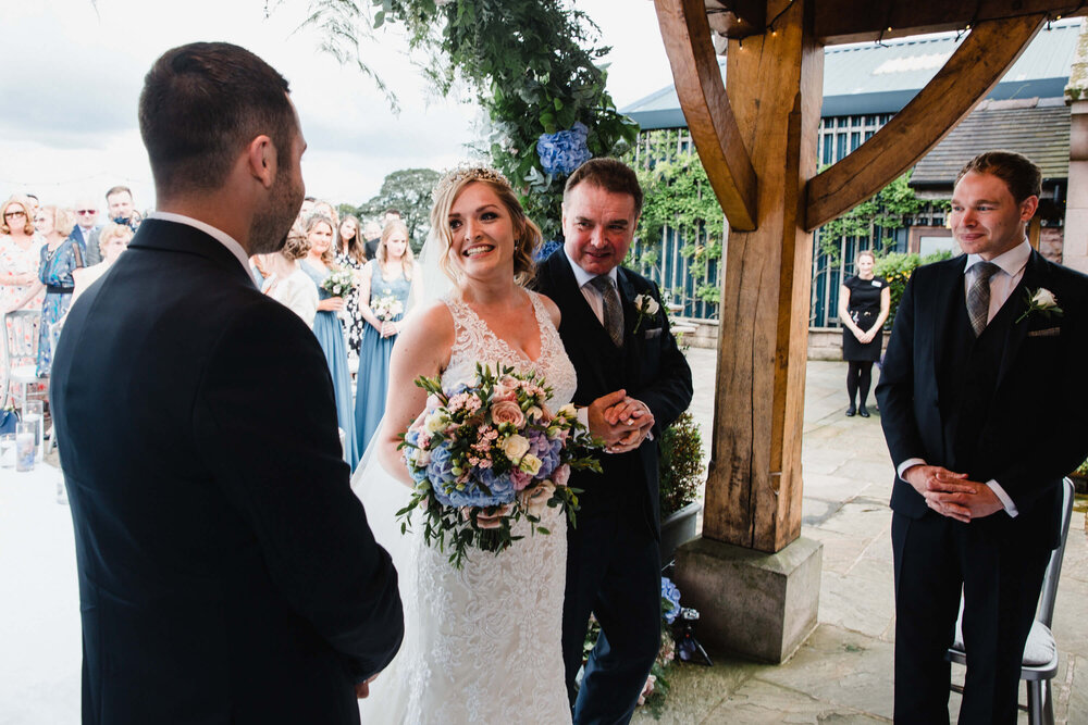 bride looking on at groom under quaint pagoda archway