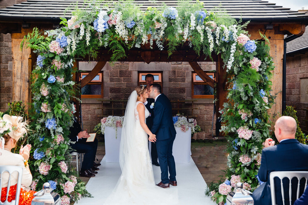 first kiss of newlyweds to end the ceremony nuptials under alfresco pagoda 