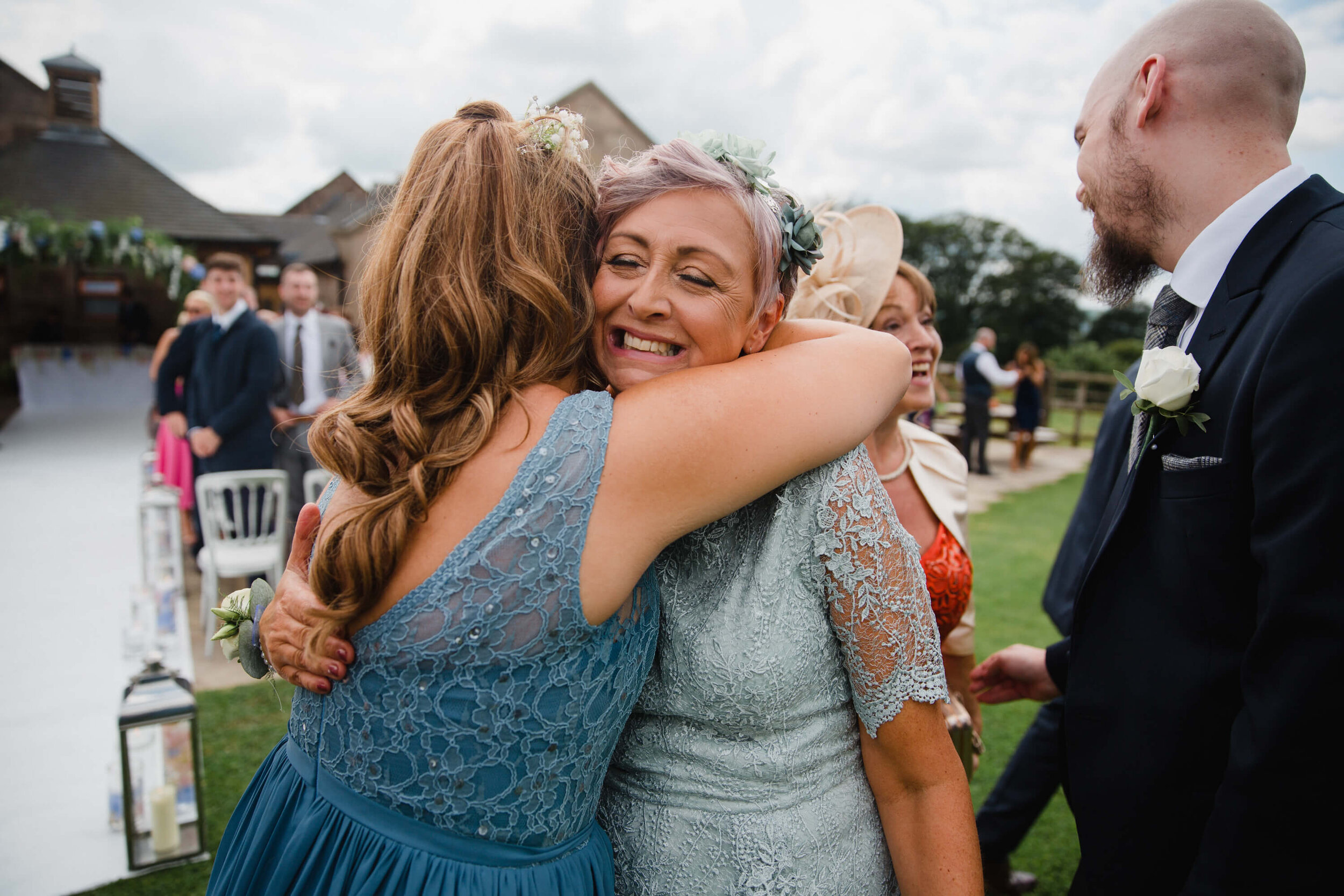 mother of groom shares hug with bridesmaid
