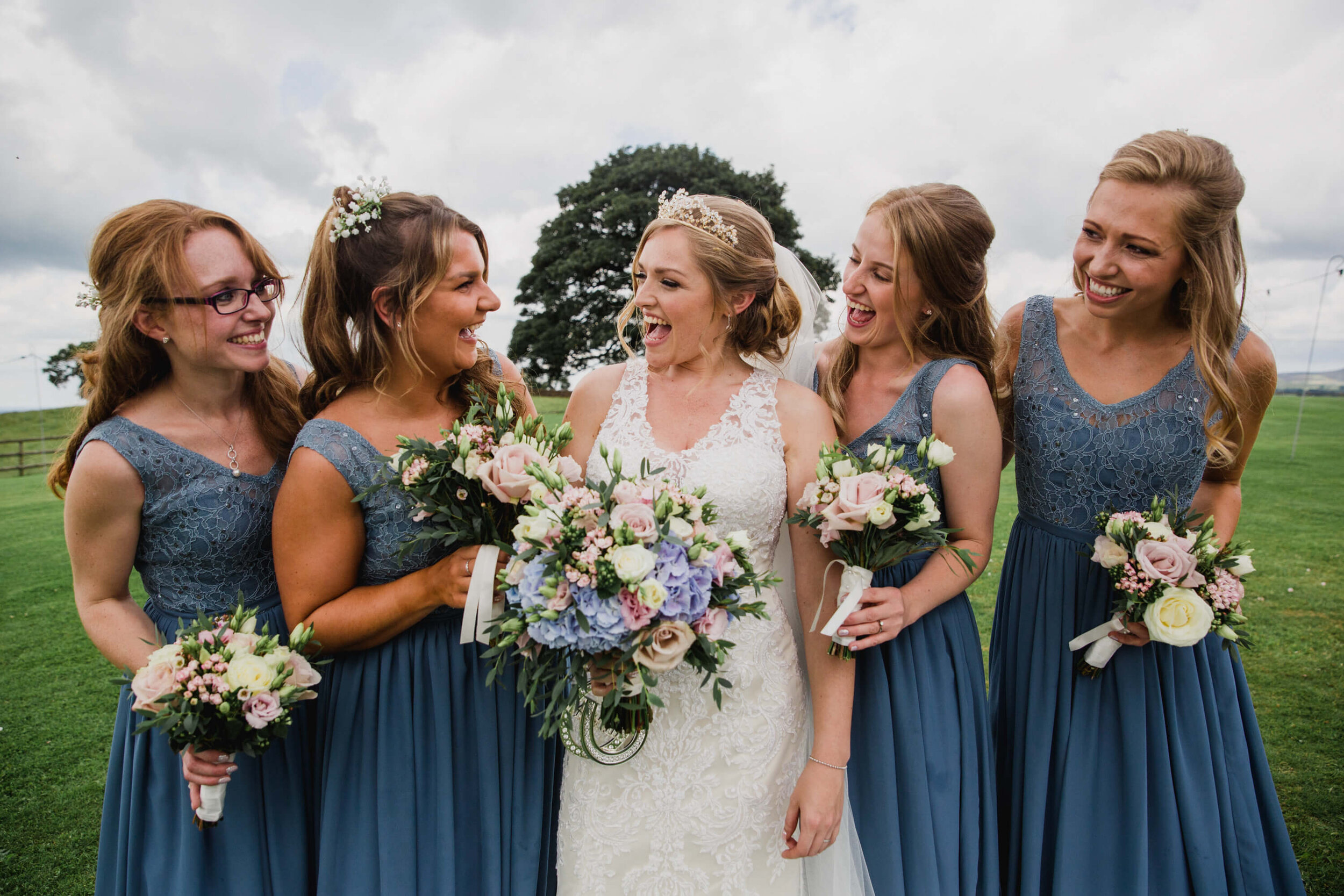 bride and bridesmaids holding bouquets with scenic backdrop 
