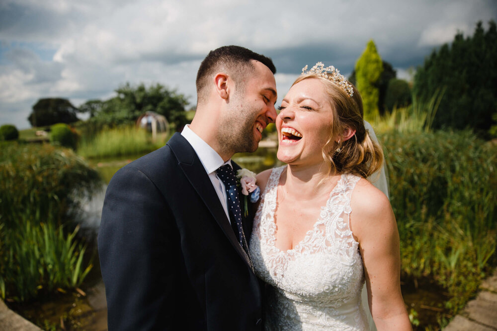 bride and groom share a joke together in gardens