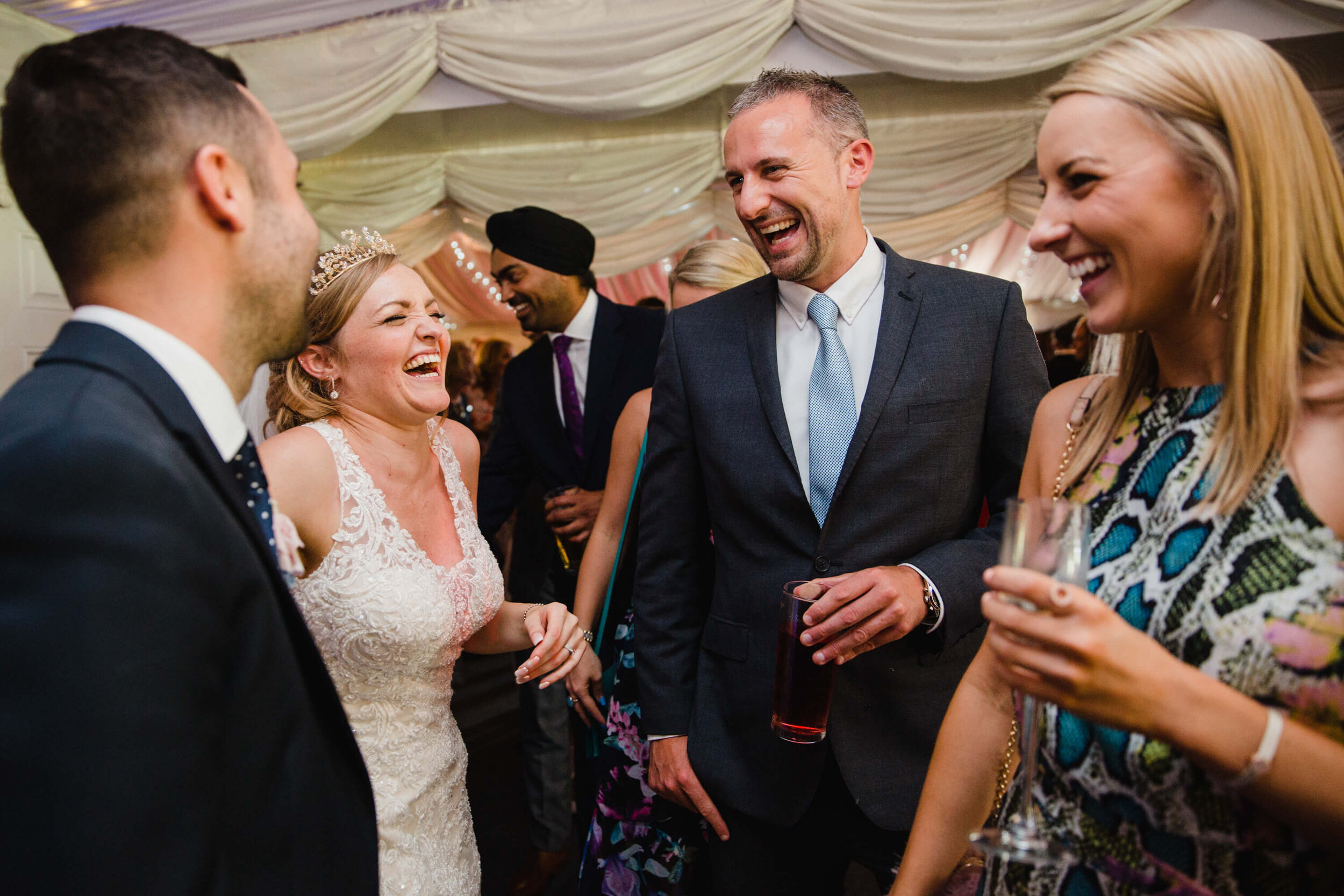 wedding party guests laughing with newlyweds