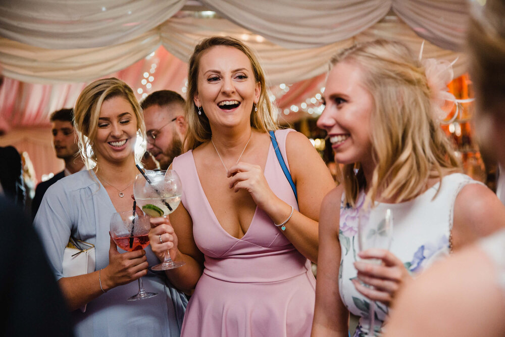 candid natural documentary moment as guests laugh with couple