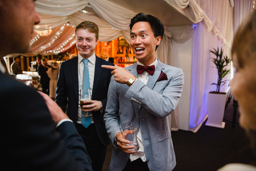 guests greeting newly wedded couple while entering room for meal