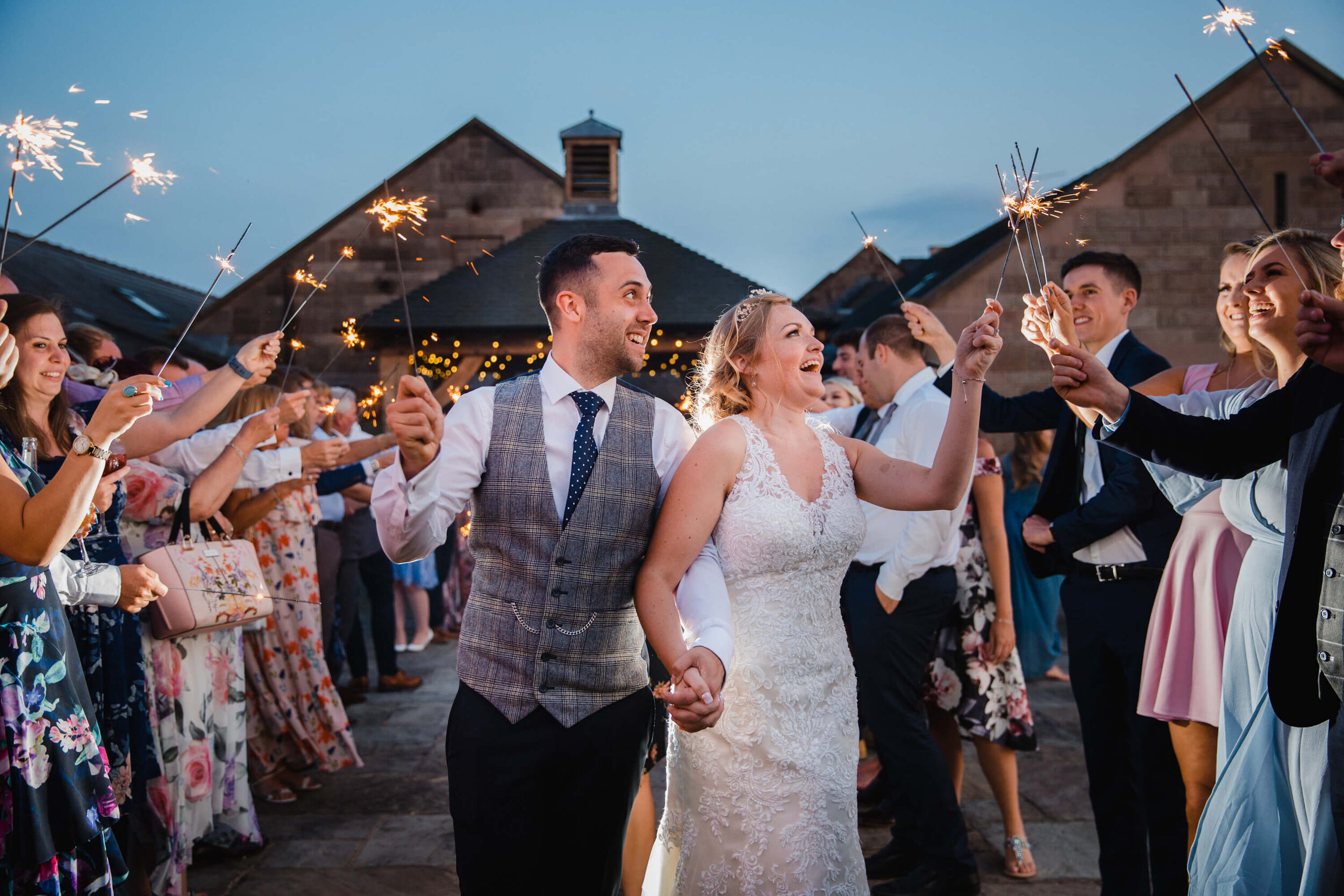 bride shares moment with guests during sparkler exit on acreage of Heaton House Farm