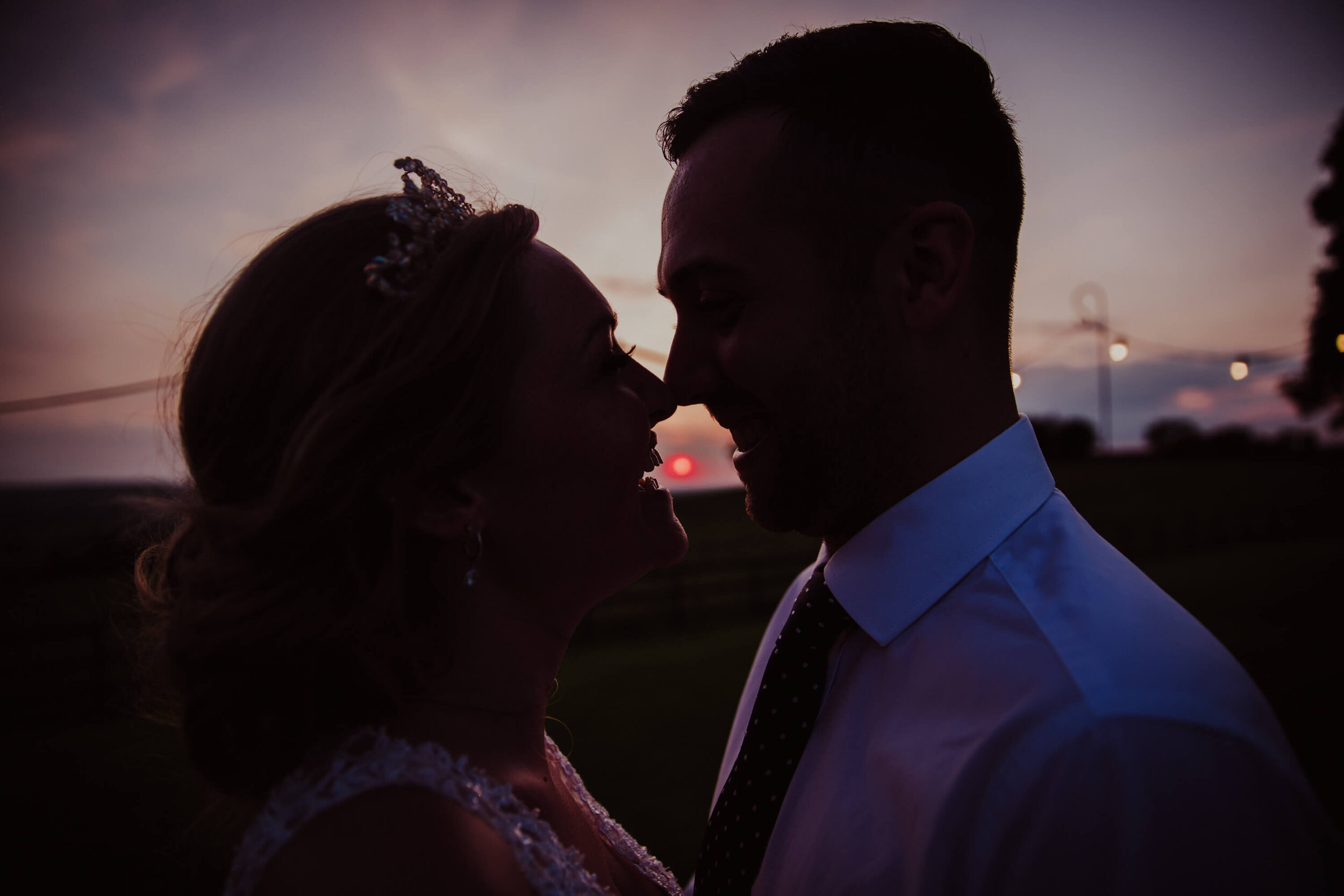 low exposure silhouette portrait of bride and groom during sunset