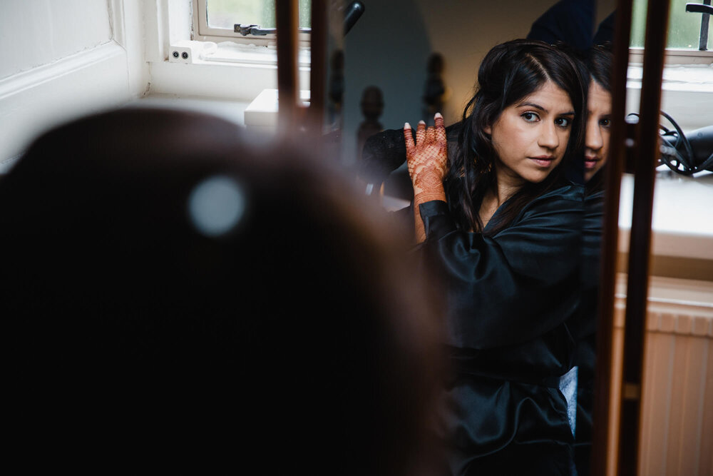 bride dressing hair in mirror