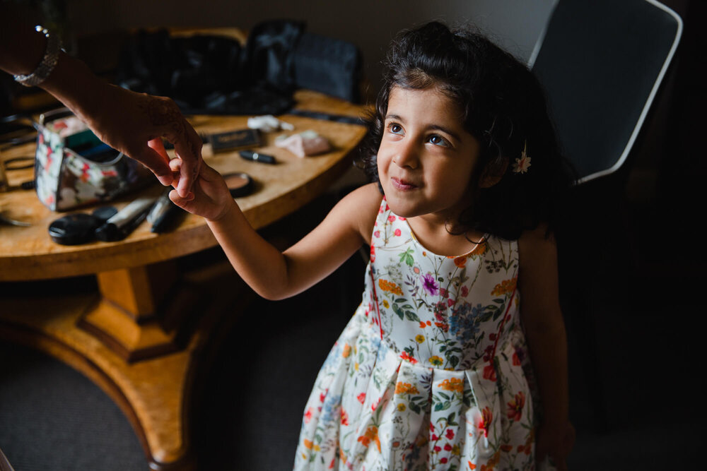 intimate moment with flower girl holding mothers hand 