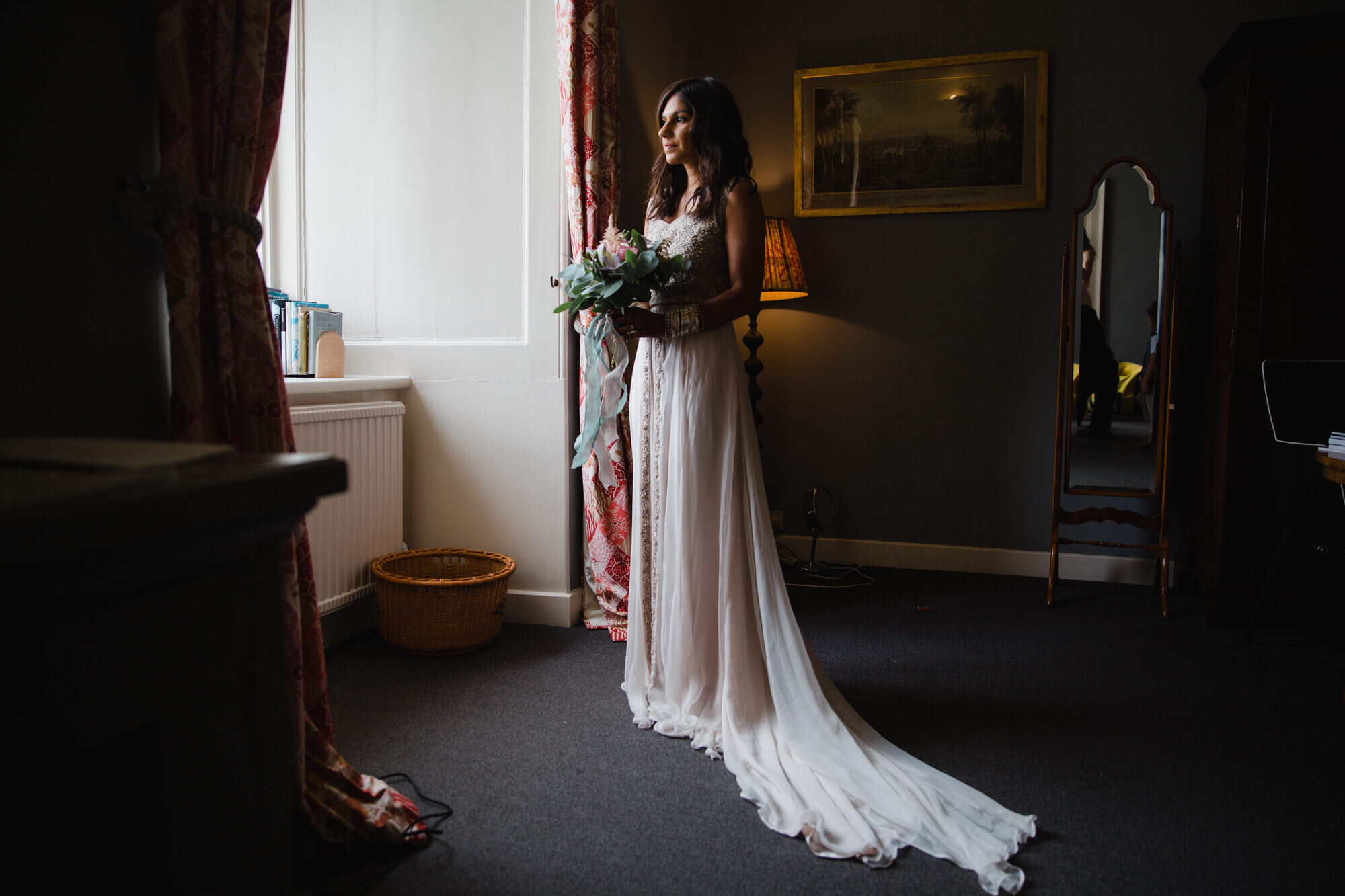 wide angle lens portrait photograph of bride in window light at award winning venue